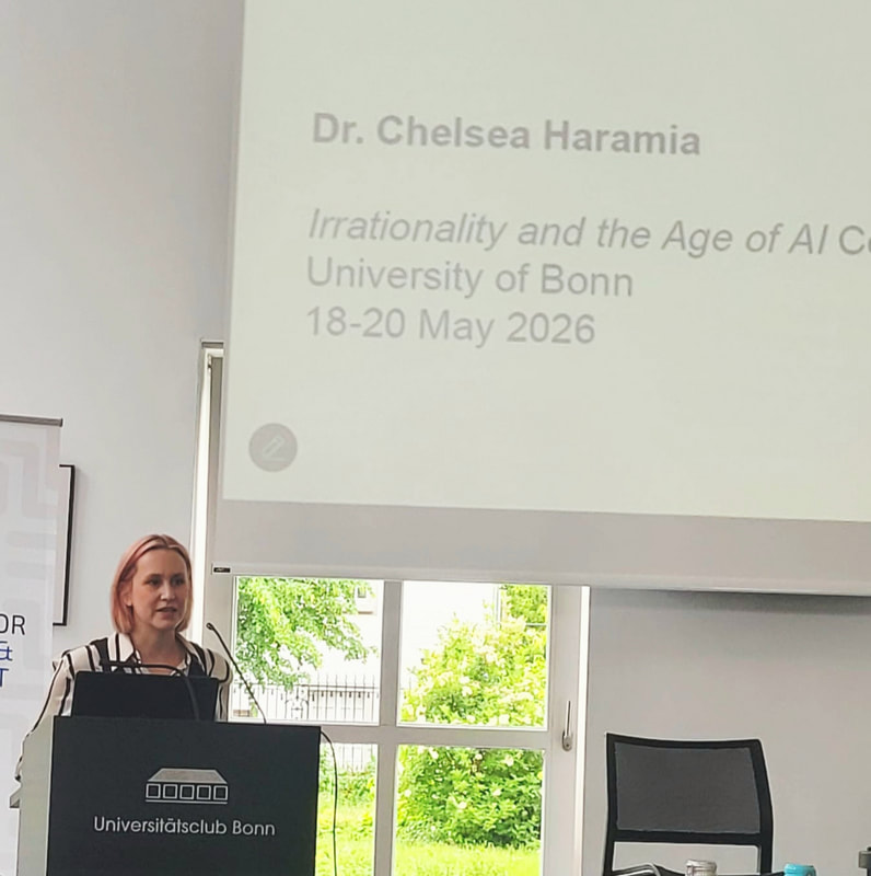 Me standing at a lectern speaking into a microphone with part of a large screen behind me containing my name and conference info