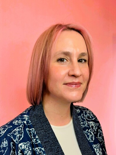 Dr. Chelsea Haramia sitting in a chair while facing the camera and smiling